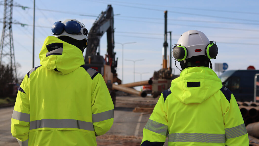 Kaksi työntekijää tarkastelee Vihdintien työmaata suojavarusteissa. Länsiratikoiden valmistelevat työt aloitettiin maaliskuussa Vihdintien ylikulkusilloilla.